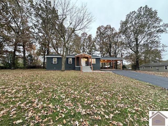 ranch-style house with a front yard, a porch, and a carport