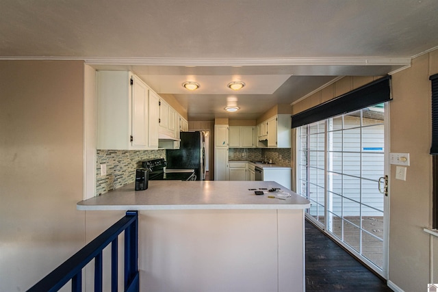 kitchen with white cabinets, decorative backsplash, kitchen peninsula, and black range with electric cooktop