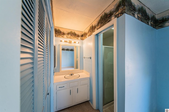 bathroom featuring vanity, a textured ceiling, and walk in shower