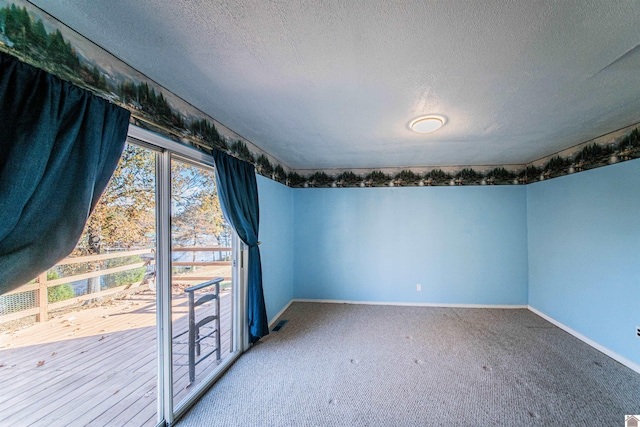 carpeted spare room with a textured ceiling