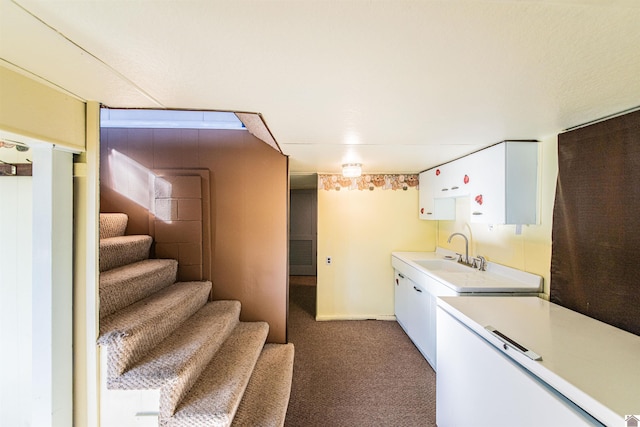 clothes washing area with dark carpet and sink