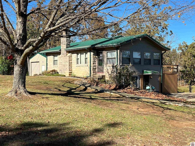 view of front of property with a front yard, a garage, and an outdoor structure