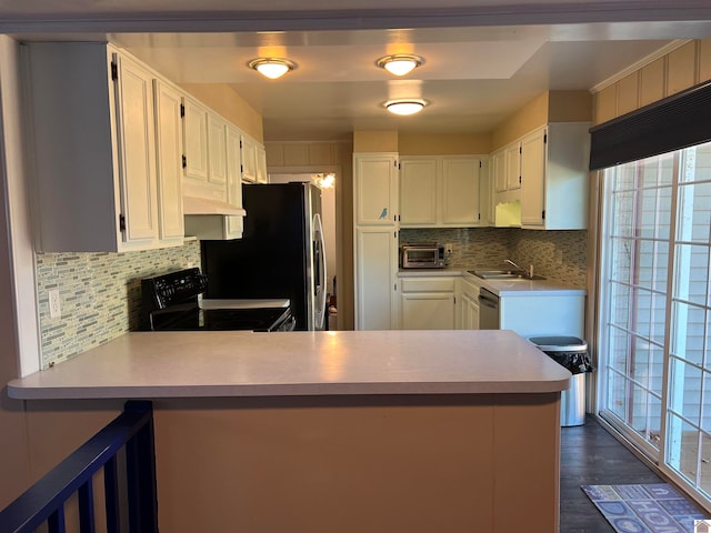 kitchen featuring backsplash, white cabinetry, dark hardwood / wood-style flooring, kitchen peninsula, and stainless steel appliances