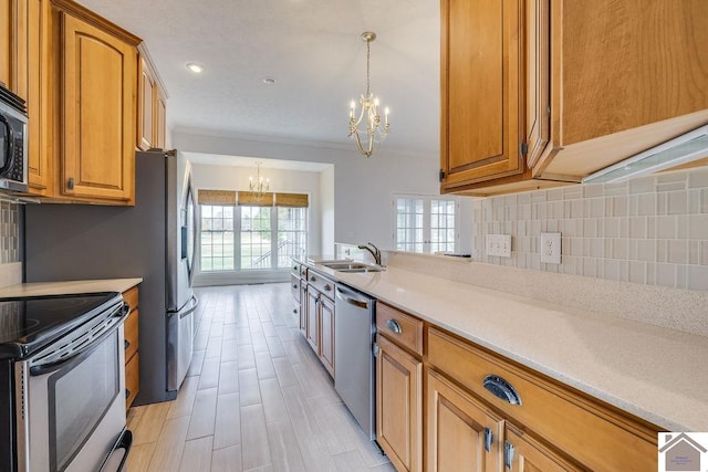 kitchen with a notable chandelier, sink, backsplash, pendant lighting, and appliances with stainless steel finishes