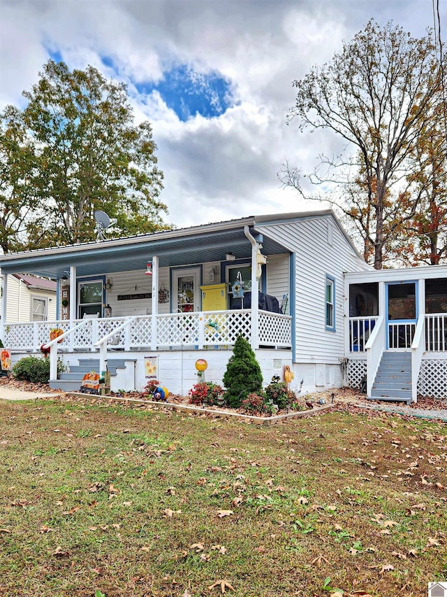 manufactured / mobile home featuring covered porch, a front yard, and a sunroom