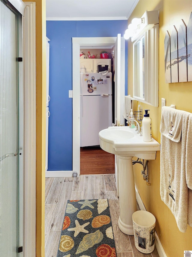 bathroom featuring hardwood / wood-style flooring and crown molding