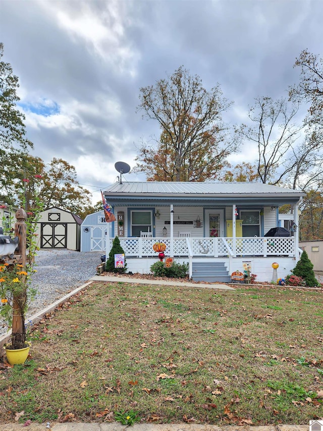 view of front facade featuring covered porch, a front yard, and a storage unit