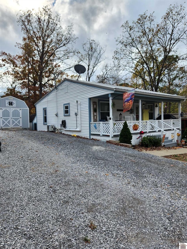 view of front of house featuring central AC unit, a porch, and a shed