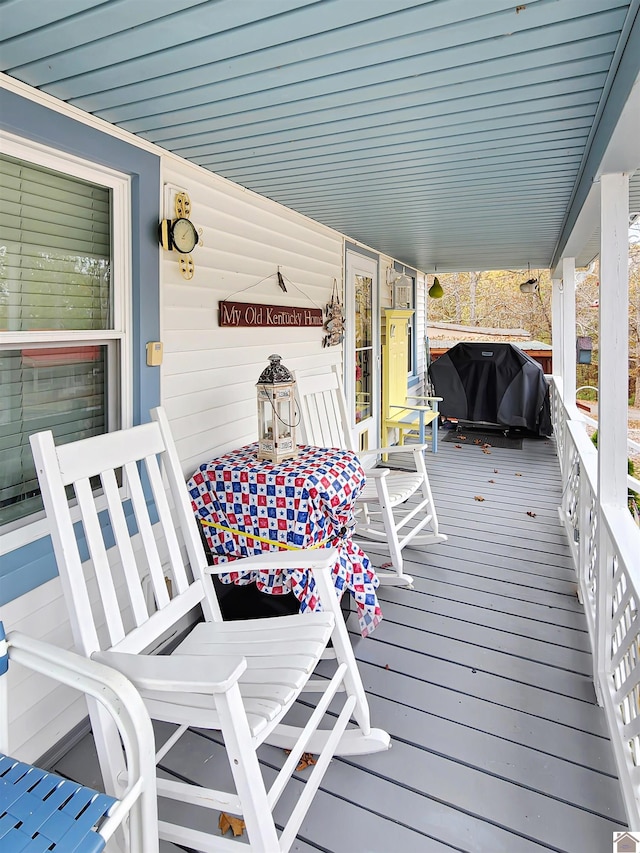 wooden terrace with a porch and area for grilling