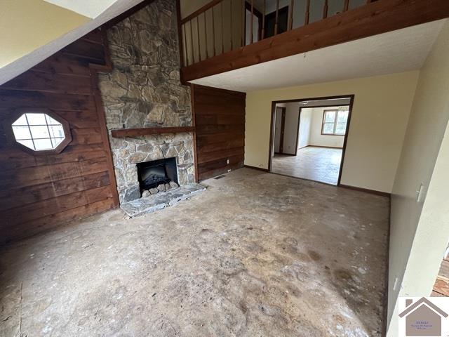 unfurnished living room with a stone fireplace