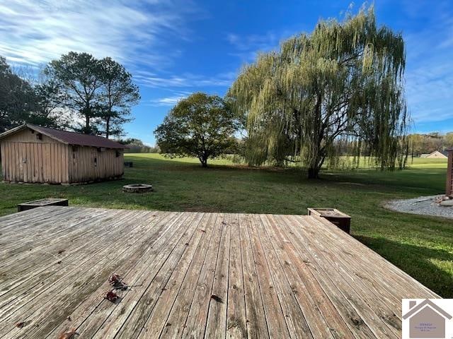 deck with a yard, an outdoor fire pit, and a storage shed