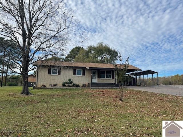 view of front of home with a carport and a front lawn