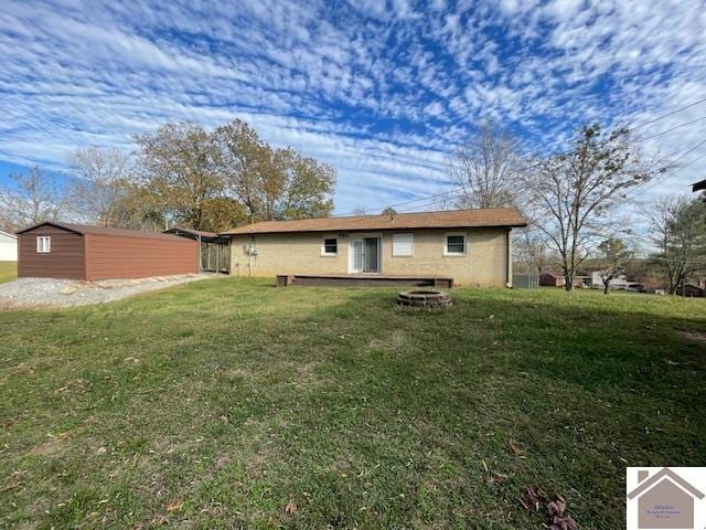 back of house with a yard and a fire pit