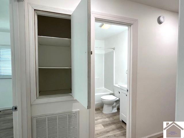 bathroom with hardwood / wood-style floors, vanity, and toilet