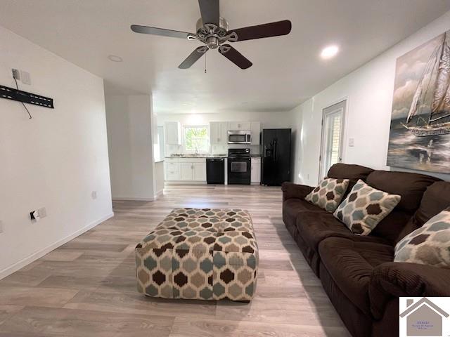 living room with light hardwood / wood-style floors and ceiling fan