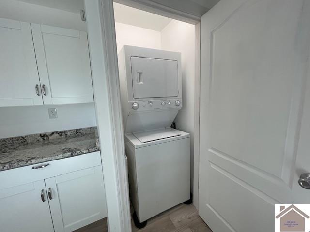 clothes washing area with stacked washer and dryer and light hardwood / wood-style flooring