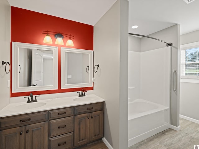 bathroom with wood-type flooring, vanity, and bathtub / shower combination