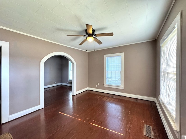 spare room with dark hardwood / wood-style floors, ceiling fan, ornamental molding, and a wealth of natural light