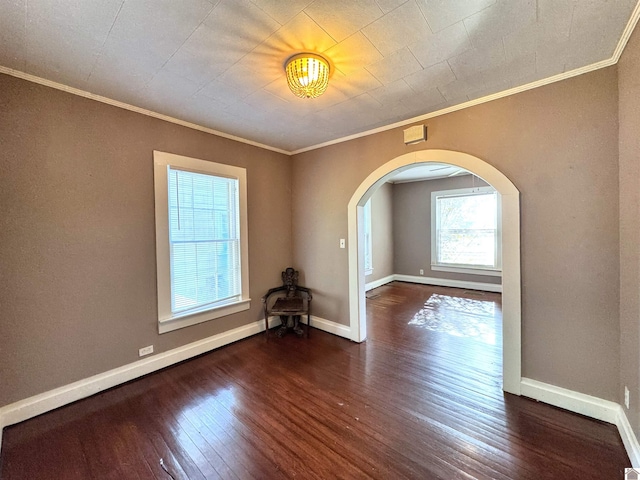 spare room with ornamental molding and dark wood-type flooring