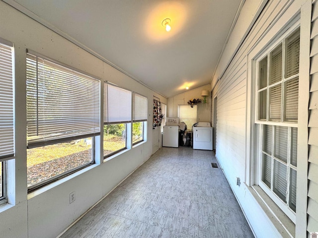 unfurnished sunroom with lofted ceiling and washing machine and clothes dryer