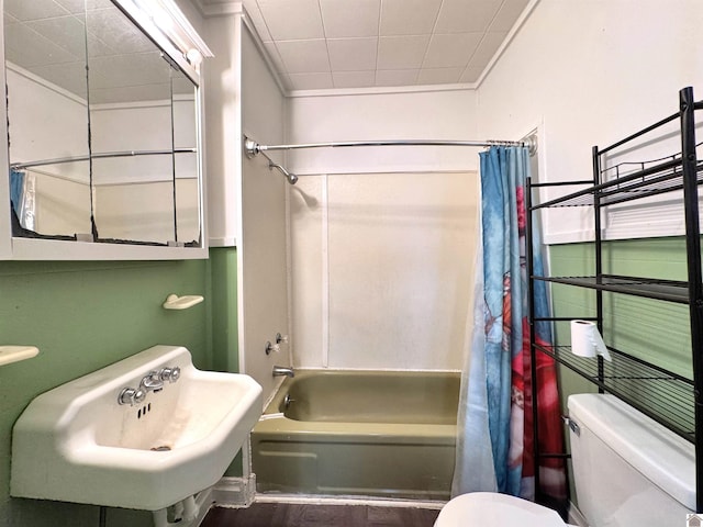 full bathroom with sink, toilet, ornamental molding, and shower / tub combo with curtain