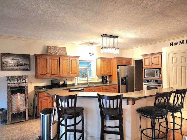 kitchen featuring a textured ceiling, stainless steel appliances, hanging light fixtures, and crown molding