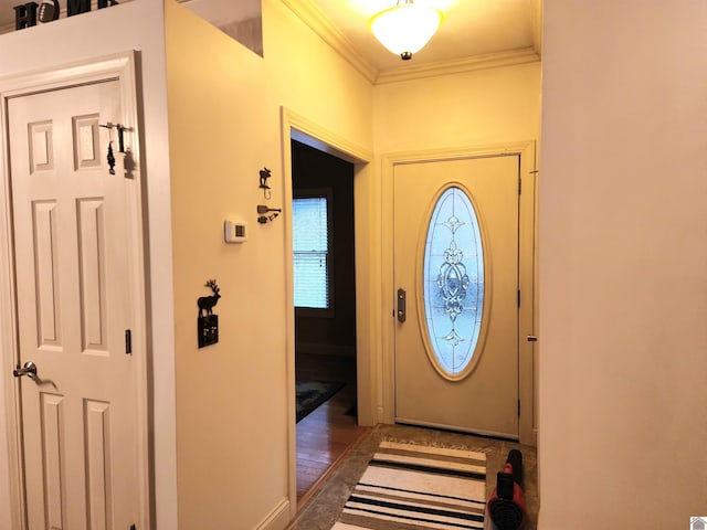 entryway with dark hardwood / wood-style flooring and crown molding