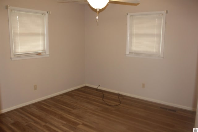 empty room featuring ceiling fan and dark wood-type flooring