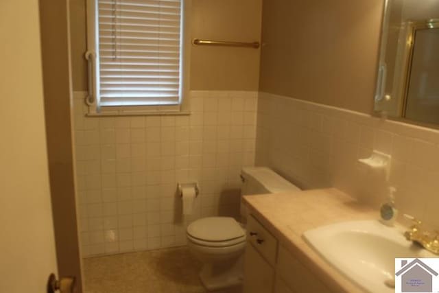 bathroom with walk in shower, tile walls, and toilet