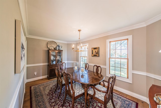 dining room with an inviting chandelier, ornamental molding, and hardwood / wood-style flooring