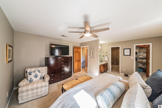 carpeted bedroom featuring a walk in closet, ceiling fan, a closet, and ensuite bathroom