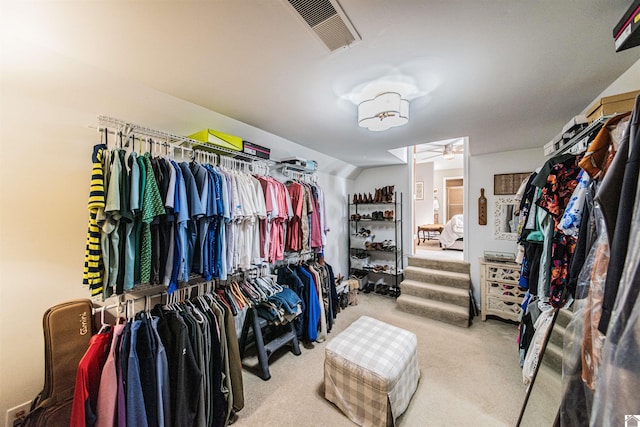 spacious closet with light carpet, ceiling fan, and lofted ceiling