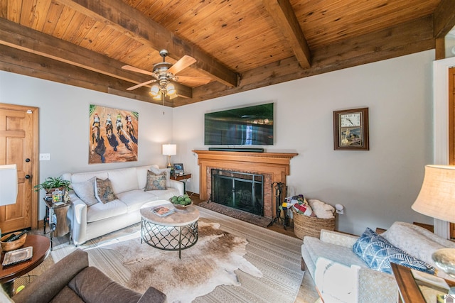 living room with beamed ceiling, ceiling fan, and wood ceiling