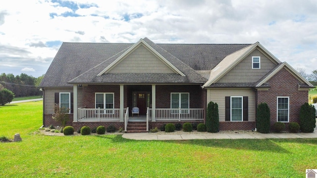 craftsman inspired home featuring covered porch and a front yard