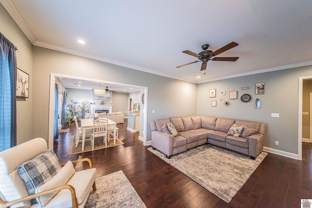 living room featuring ceiling fan, dark hardwood / wood-style flooring, and crown molding