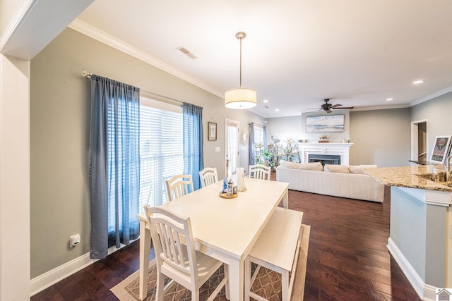 dining area featuring ceiling fan, ornamental molding, and dark wood-type flooring