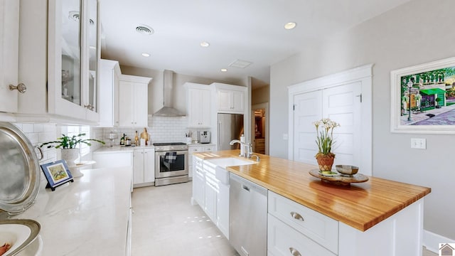 333 N 7th St Unit B, Paducah, KY 42001 - kitchen featuring a sink, decorative backsplash, wall chimney range hood, white cabinets, and appliances with stainless steel finishes