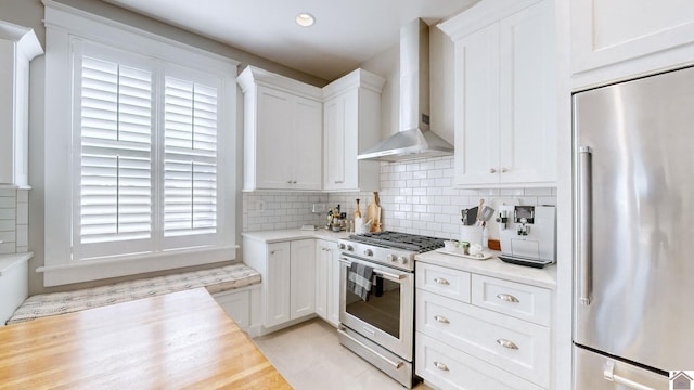 333 N 7th St Unit B, Paducah, KY 42001 - kitchen with white cabinetry, high end appliances, wall chimney range hood, and tasteful backsplash