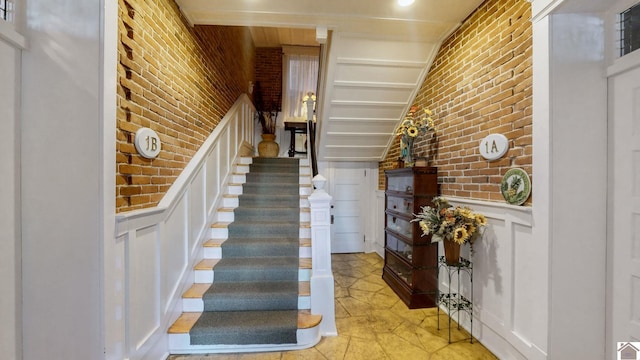 333 N 7th St Unit B, Paducah, KY 42001 - stairway featuring wainscoting, brick wall, and a decorative wall