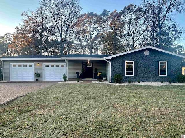 ranch-style home featuring a garage and a front lawn