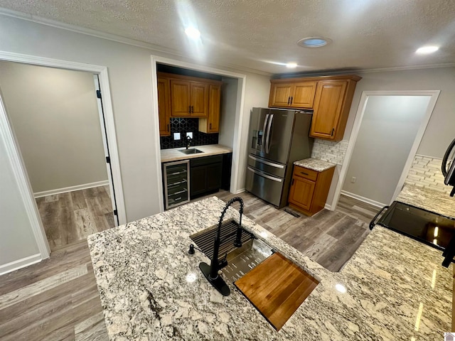 kitchen with stainless steel refrigerator with ice dispenser, tasteful backsplash, wine cooler, and light hardwood / wood-style flooring