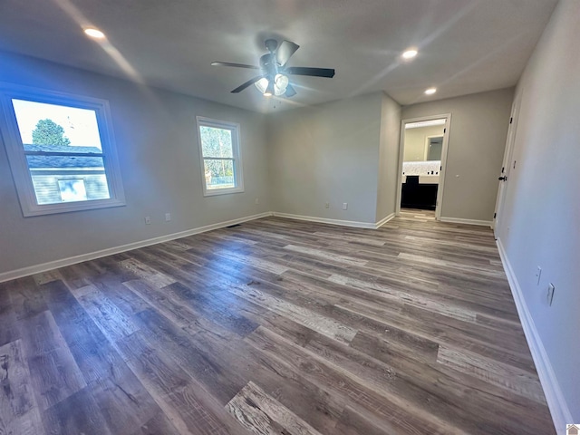 spare room featuring ceiling fan, dark hardwood / wood-style flooring, and a wealth of natural light