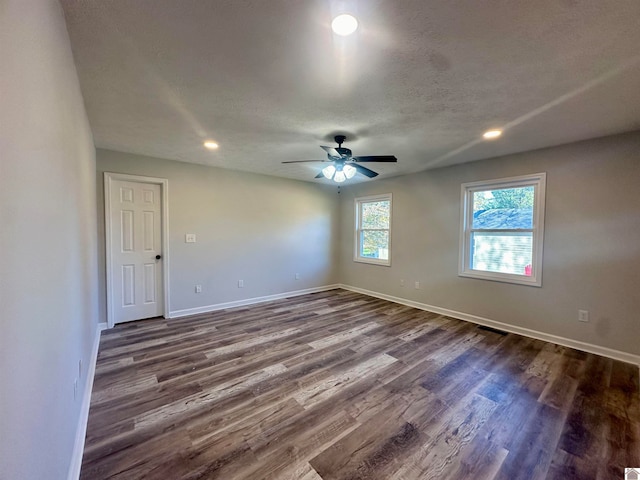 empty room featuring a textured ceiling, dark hardwood / wood-style floors, and ceiling fan