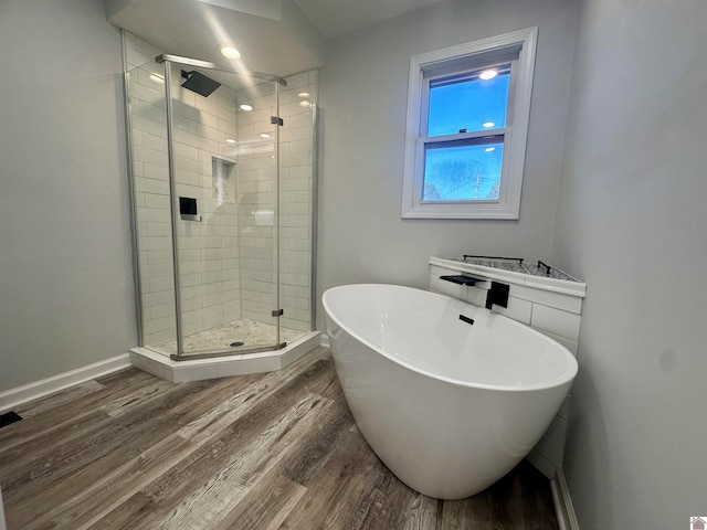 bathroom with wood-type flooring and independent shower and bath