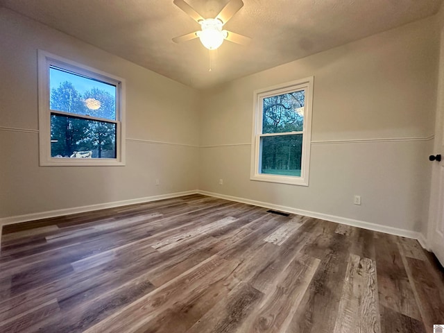 spare room with ceiling fan and dark wood-type flooring