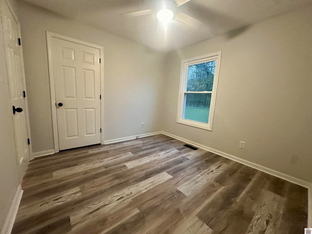 spare room featuring ceiling fan and dark hardwood / wood-style floors