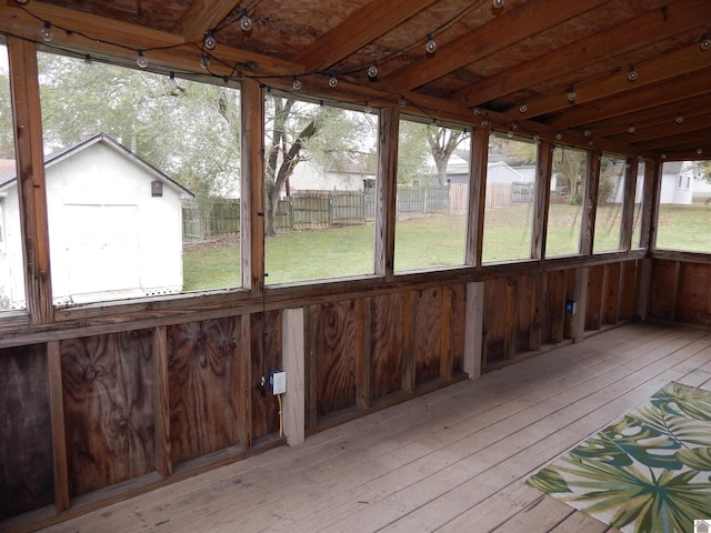 unfurnished sunroom featuring plenty of natural light and beam ceiling