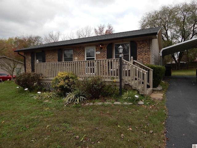 single story home featuring a carport and a front lawn