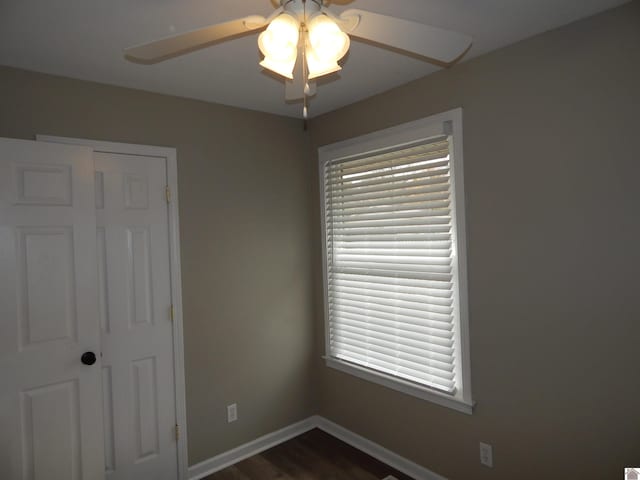 unfurnished bedroom with dark hardwood / wood-style flooring, a closet, and ceiling fan