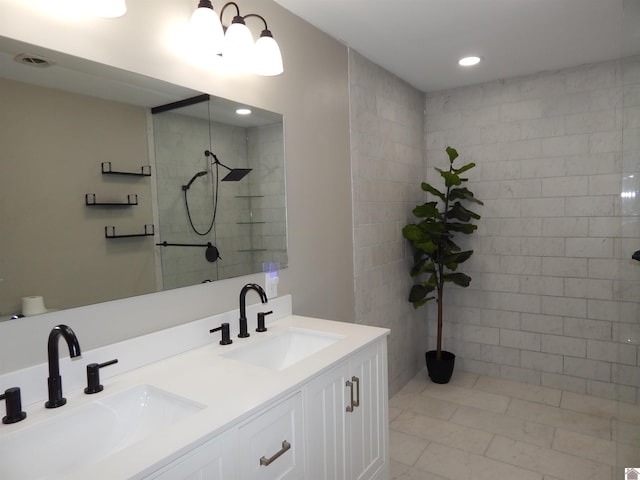 bathroom with tile patterned floors, vanity, and tiled shower